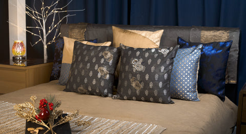 bed with golden, blue and dark patterned cushions