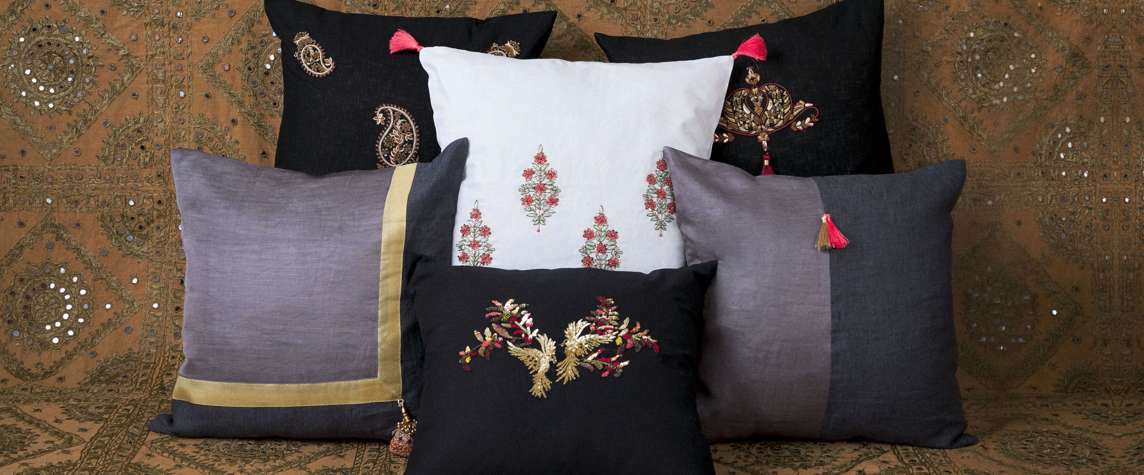 coloured embroidered cushions in a zardozi fabric background 