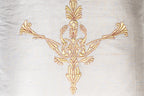 detail of the golden peacock embroidered on an Exclusive white silk cushion with golden peacock zardozi embroidery